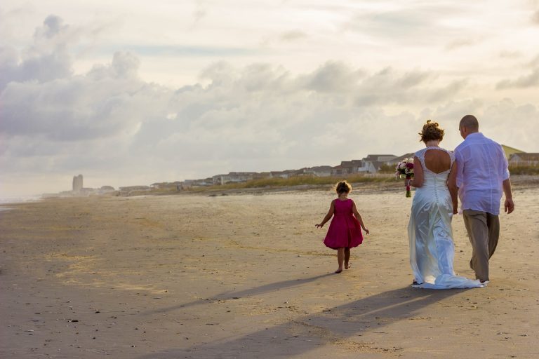 Hochzeitspaar mit Kind am Strand