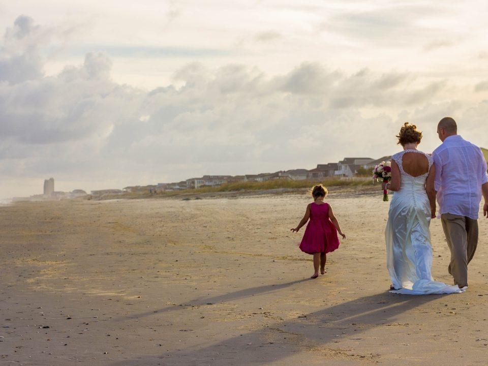 Hochzeitspaar mit Kind am Strand